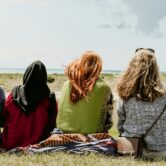 group of people sitting on grass field during daytime