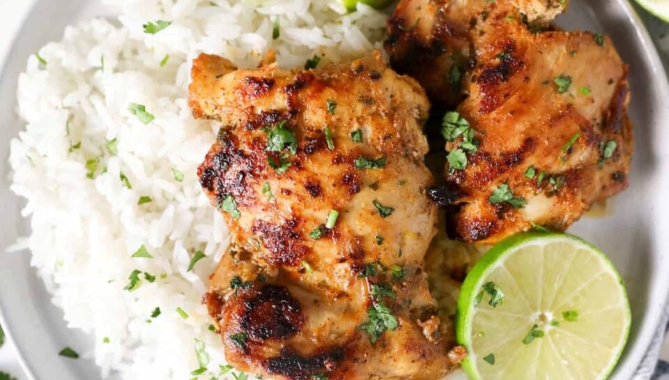 Cilantro-Lime-Chicken-V2 plate with white rice, cut limes, and two pieces of cilantro chicken