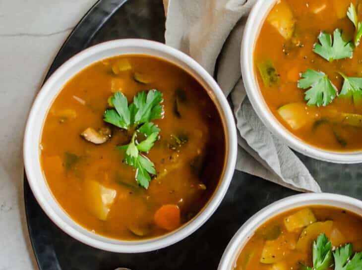 th-cancer-fighting-soup-3-730x1058 overhead shot of three bowls of soup on a tray with spoons and a napkin